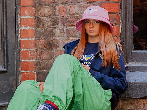 Eurovision merchandise photo with a model wearing a trendy pink bucket hat